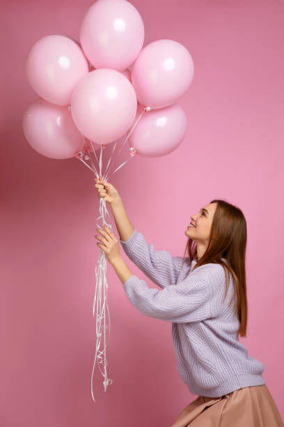 istock birthday girl posing with balloons 1217603061