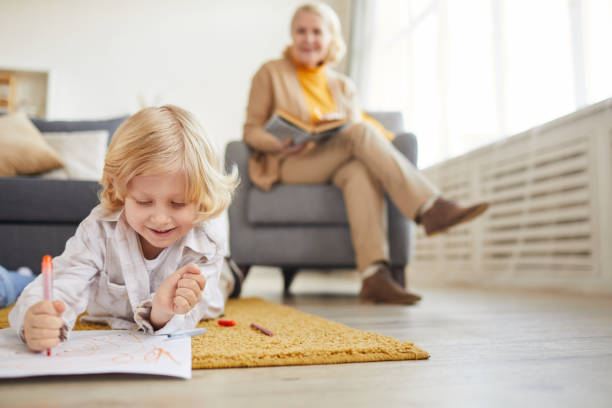 mały chłopiec rysunek na podłodze - grandmother reading child grandson zdjęcia i obrazy z banku zdjęć