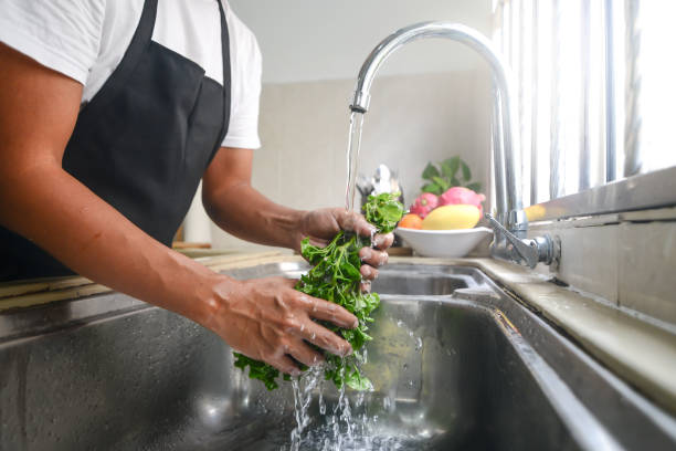 istock Rinsing vegetables in the sink 1217605894