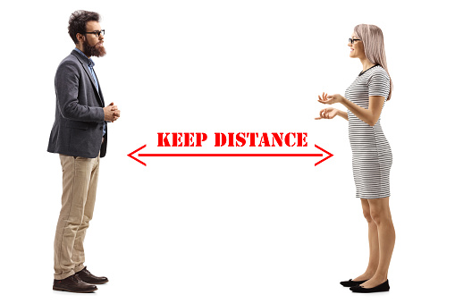 Full length profile shot of a man and woman talking and an arrow drawn between them with message keep distance isolated on white background