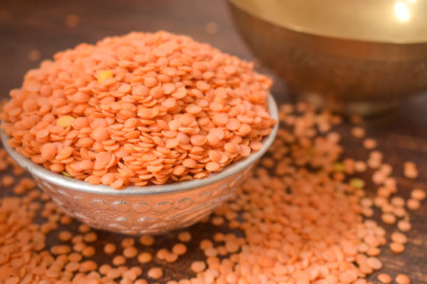 istock Dry Split Red Lentils in a Silver bowl on wooden old Table. rustic style 1217607627