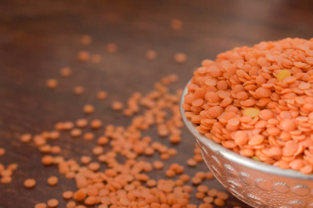 istock Dry Split Red Lentils in a Silver bowl on wooden old Table. rustic style 1217607631