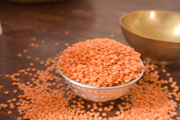 Dry Split Red Lentils in a Silver bowl on wooden old Table. rustic style