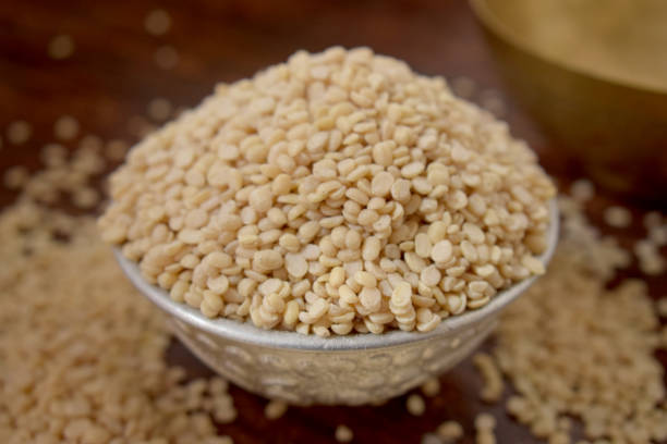 Split White Urad Dal. Vigna mungo Beans  in a Silver bowl on wooden old Table. Rustic style