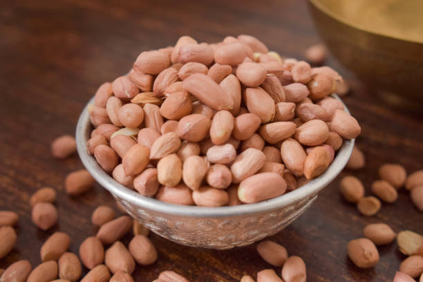 istock Peeled peanuts in a Silver bowl on wooden old Table. rustic style 1217608034