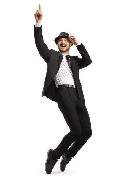 istock Man in a black suit and hat dancing on tiptoes 1217608193
