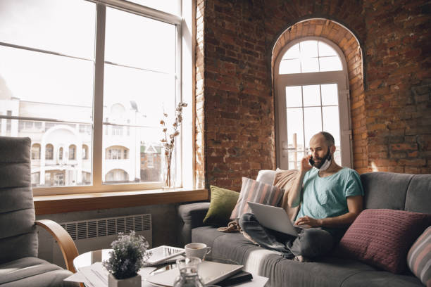 istock Young man doing yoga at home while being quarantine and freelance working 1217609318