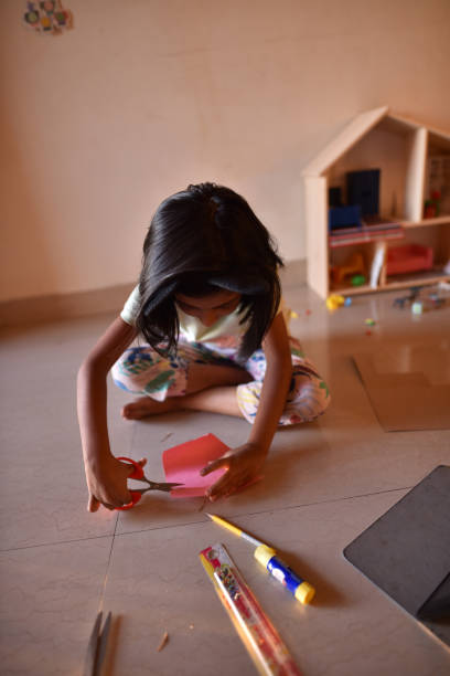 istock Girl making paper craft at home 1217609641