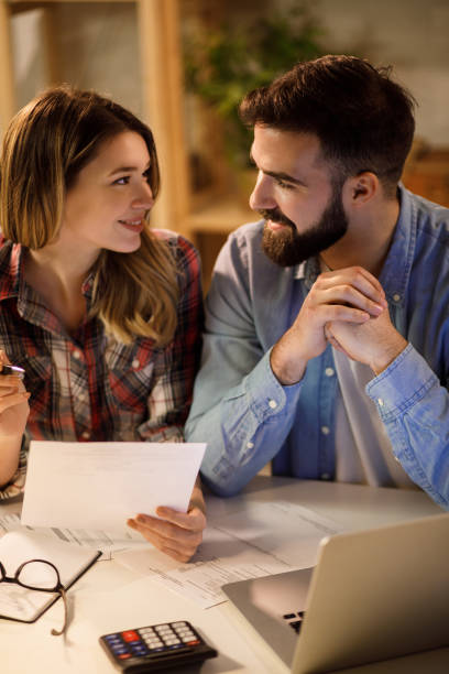 istock Young couple working on their finances together at home 1217609827