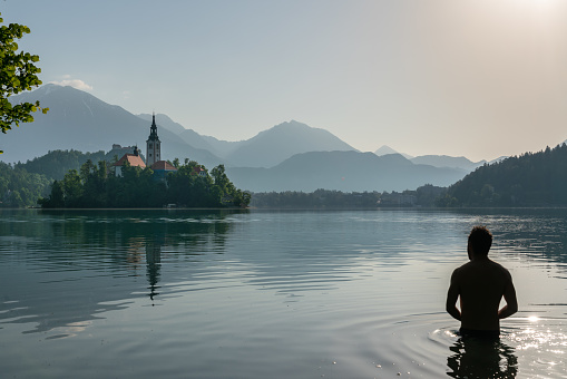 Silhouette of an European man bathing in lake Bled while practicing the Wim Hof â€‹â€‹meditation method