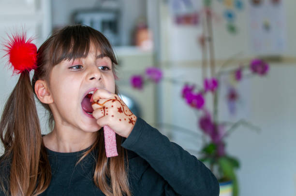 istock Cute girl eating  candy sweet sugar 1217611362