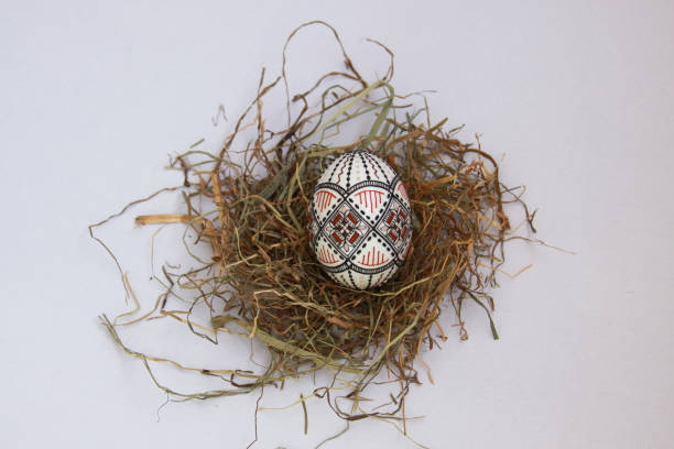 Traditional painted handmade Easter egg on hay stock photo
