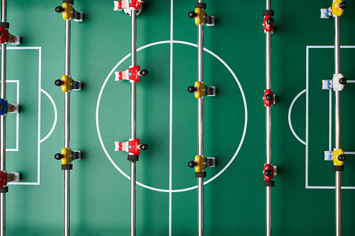 Table football game, close-up. Table soccer field with football players. Leisure and entertainment concept