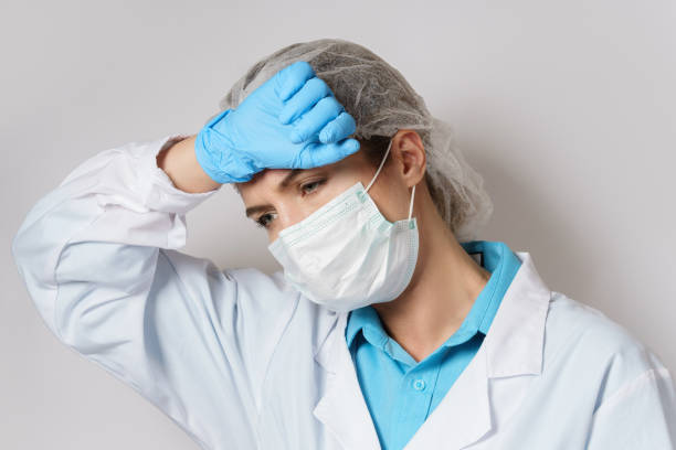 istock Tiredness - young female doctor with a headache 1217614881
