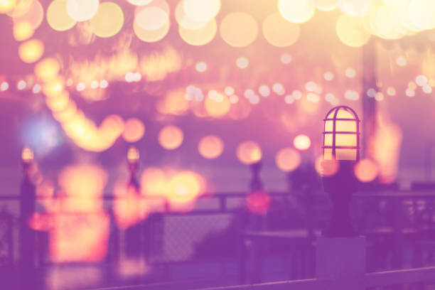 blurred bokeh light on sunset with yellow lights decor in beach restaurant