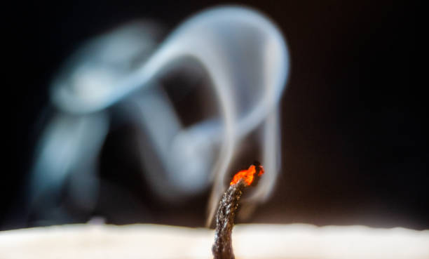 mèche rougeoyante de bougie avec la fumée - bougie gros plans fumé photos et images de collection