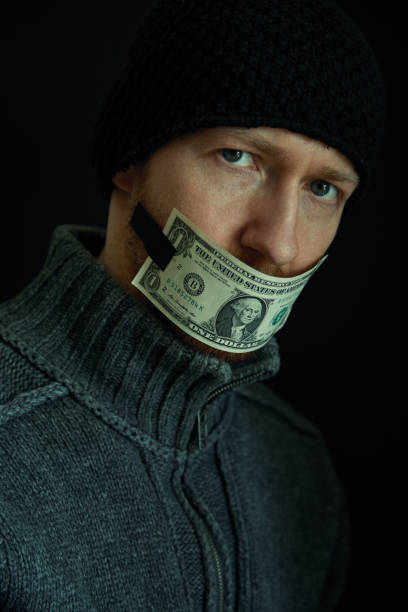 image conceptuelle de corruption et de corruption. silencieux pour de l’argent. verticale de l’homme avec sa bouche fermée avec un billet de banque d’un dollar. - currency silence censorship behavior photos et images de collection