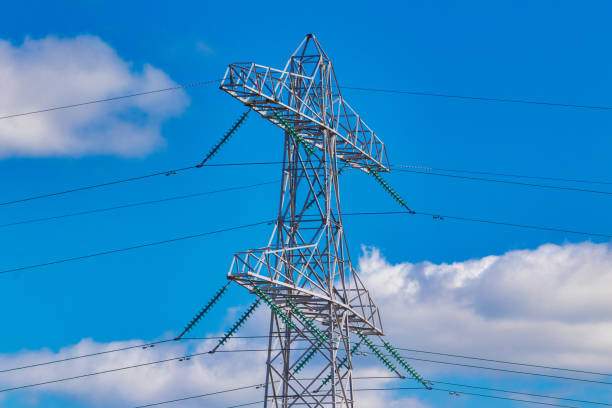 istock Power lines pylon with perfect blue sky and cumulus clouds 1217621575
