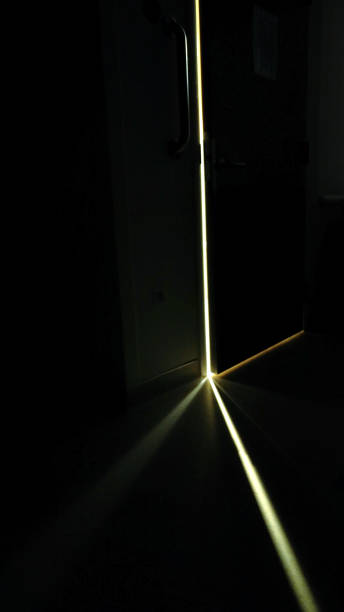 istock Crack of Light From Behind Dark Open Door 1217621698
