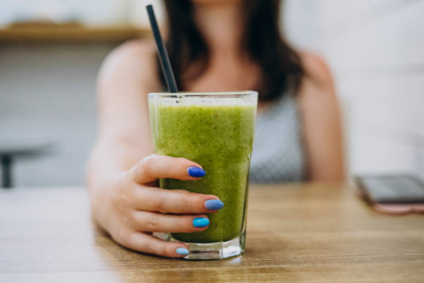 istock Female hand holds green smoothie 1217622878