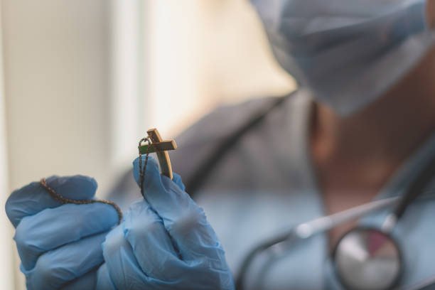 mujer doctora rezando - catolicismo fotografías e imágenes de stock