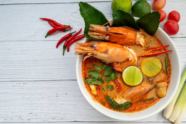 sopa de tom yum. tom yam kung es una sopa picante tailandesa con gambas, hierba de limón, lima, jengibre, galangal y leche de coco. espacio para texto - tom tom yum meal soup fotografías e imágenes de stock