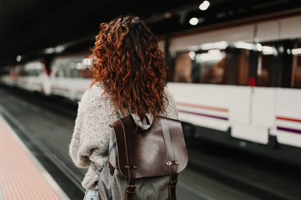 istock young beautiful woman at train station using mobile phone before catching a train. Back view. Travel, technology and lifestyle concept 1217627056