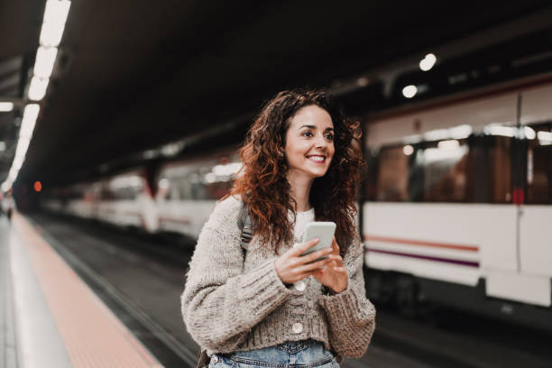 istock young beautiful woman at train station using mobile phone before catching a train. Back view. Travel, technology and lifestyle concept 1217627065