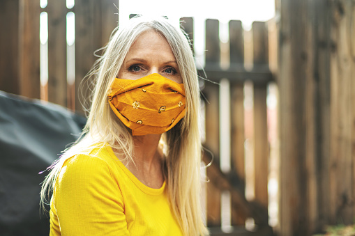 In Western Colorado Mature Adult Female Wearing Face Mask and Social Distancing Due to Infectious Virus Outbreak Pandemic Series(Shot with Canon 5DS 50.6mp photos professionally retouched - Lightroom / Photoshop - original size 5792 x 8688 downsampled as needed for clarity and select focus used for dramatic effect)