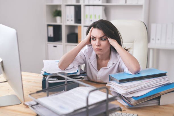 istock Young businesswoman touching her head while looking at computer screen 1217629261
