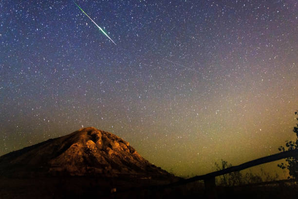 Meteor Perseid in the night sky against the backdrop of the mountain. Mount Toratau against the starry sky Meteor Perseid in the night sky against the backdrop of the mountain. Mount Toratau against a starry sky in August and a passing meteor in the sky meteor photos stock pictures, royalty-free photos & images