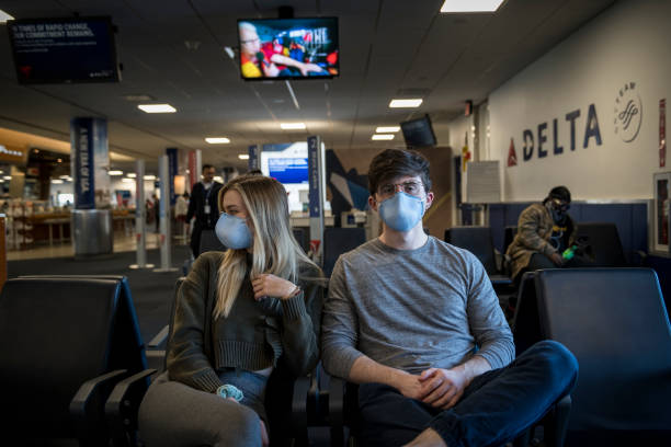 passagers portant un masque facial à l’aéroport de laguardia en raison de la pandémie covid-19 - delta air lines photos et images de collection