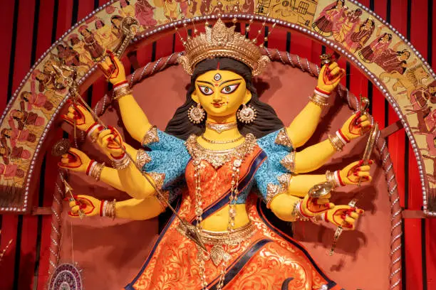 Photo of Goddess Durga idol at decorated Durga Puja pandal, shot at colored light, at Kolkata, West Bengal, India. Durga Puja is biggest religious festival of Hinduism and is now celebrated worldwide.