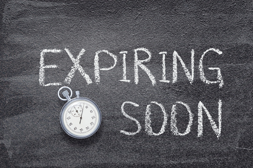 expiring soon phrase written on chalkboard with vintage precise stopwatch