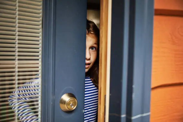 Young girl opening front door
