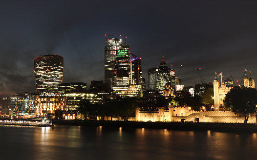 Wonderful night London city landscape from Tower bridge. Illuminated buildings and monuments as Tower castle, 30 St Mary Axe and ship on Thames river. Centre of London at midnight. City glow.