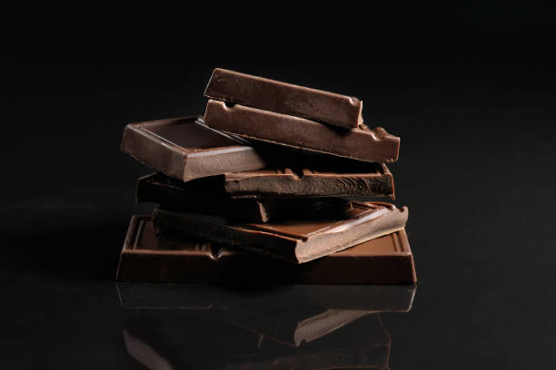 istock Broken chocolate pieces on a black background. Copy space. Close-up. 1217633839