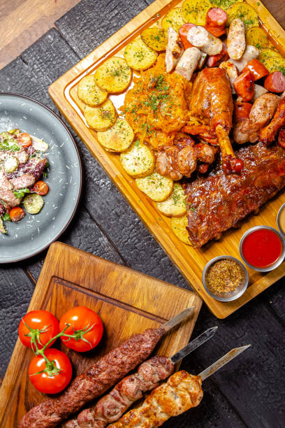 istock background black burnt charred forest, structure, shot from above, meat kebab, fried leg, turkey thigh, rustic potatoes, sauce, pork rib, on a wooden cutting board 1217633943