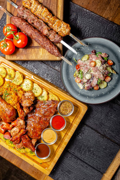 istock background black burnt charred forest, structure, shot from above, meat kebab, fried leg, turkey thigh, rustic potatoes, sauce, pork rib, on a wooden cutting board 1217633948