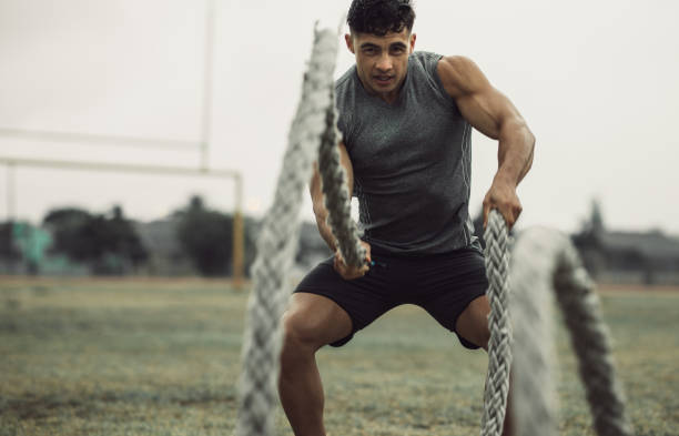 istock Muscular man working out with battling ropes 1217634393