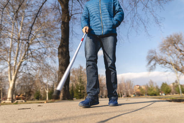 istock Young blind man using his walking cane to be sure if there is no any obstacle on his way 1217635027
