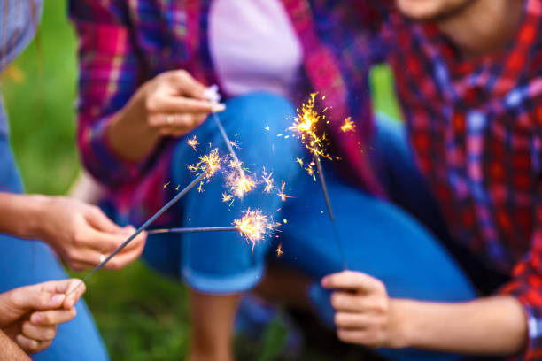 istock Friends holding sparklers in summer park. 1217635895