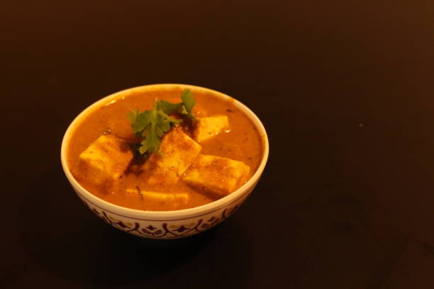 istock Paneer Butter Masala Dish in a bowl with Black Background. 1217636163