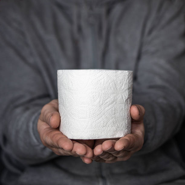 un hombre tiene en sus manos un rollo de papel higiénico. enfoque selectivo. pánico y escasez en las tiendas del coronavirus depmidense mundial - people purity personal accessory handkerchief fotografías e imágenes de stock