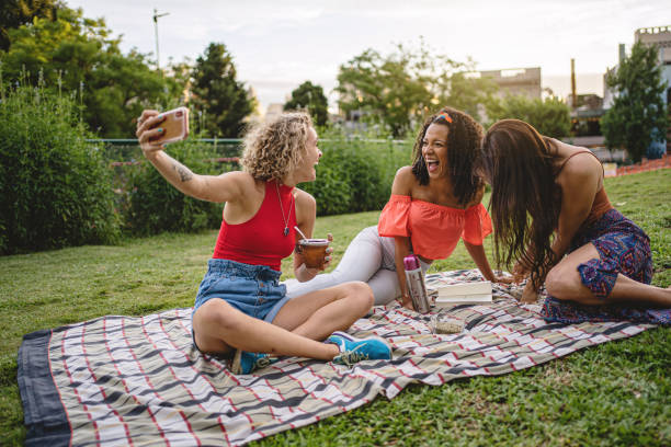 istock Latin cheerful women taking selfie while having fun at the picnic 1217637701