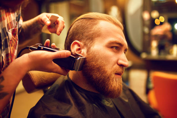 istock Man getting his beard trimmed with electric razor 1217639184