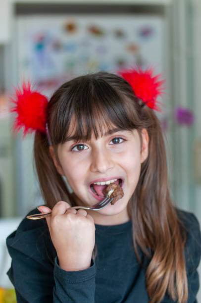 istock Cute girl eating chocolate cake 1217639568