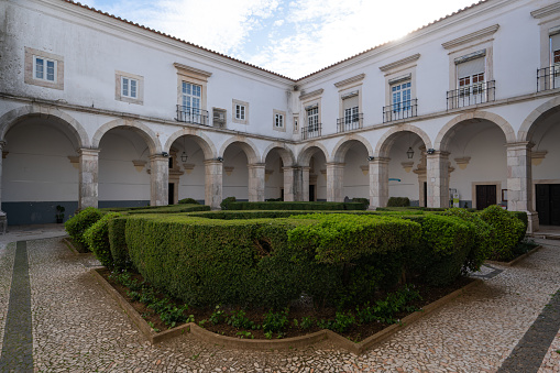 Grand entrance with traditional white door and decorative molding is framed by clean modern columns