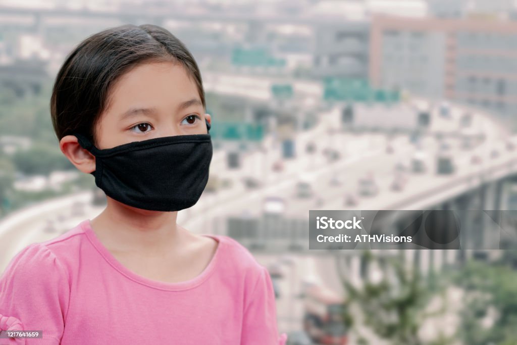 Asian Cute Kid Girl Wearing Mask For Protected Coronavirus Or Covid Kid Feel Sad While Put A Black Mask On Her Face With Air Pollution Or Virus Stock