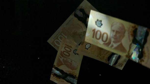 istock Falling flying american canadian dollar banknotes on a black background. High quality falling Dollar banknotes 1217641716